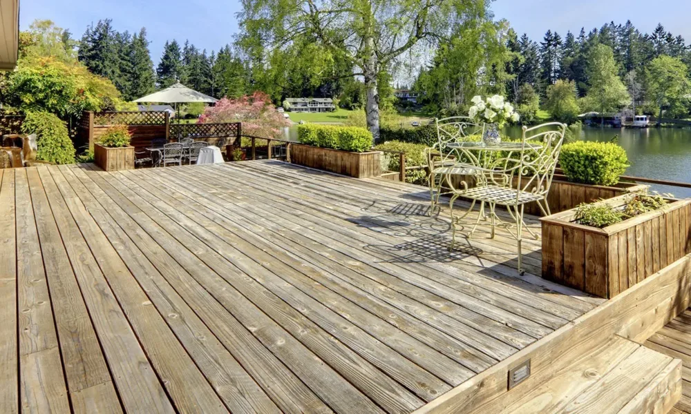 Wooden decking metail chairs pond.